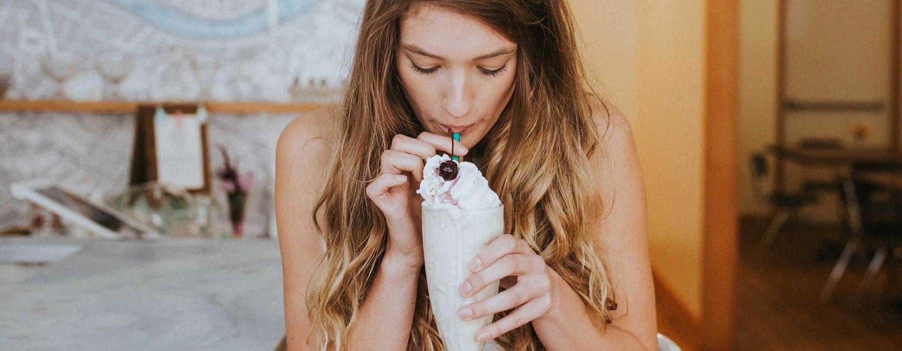 a woman drinking a milkshake